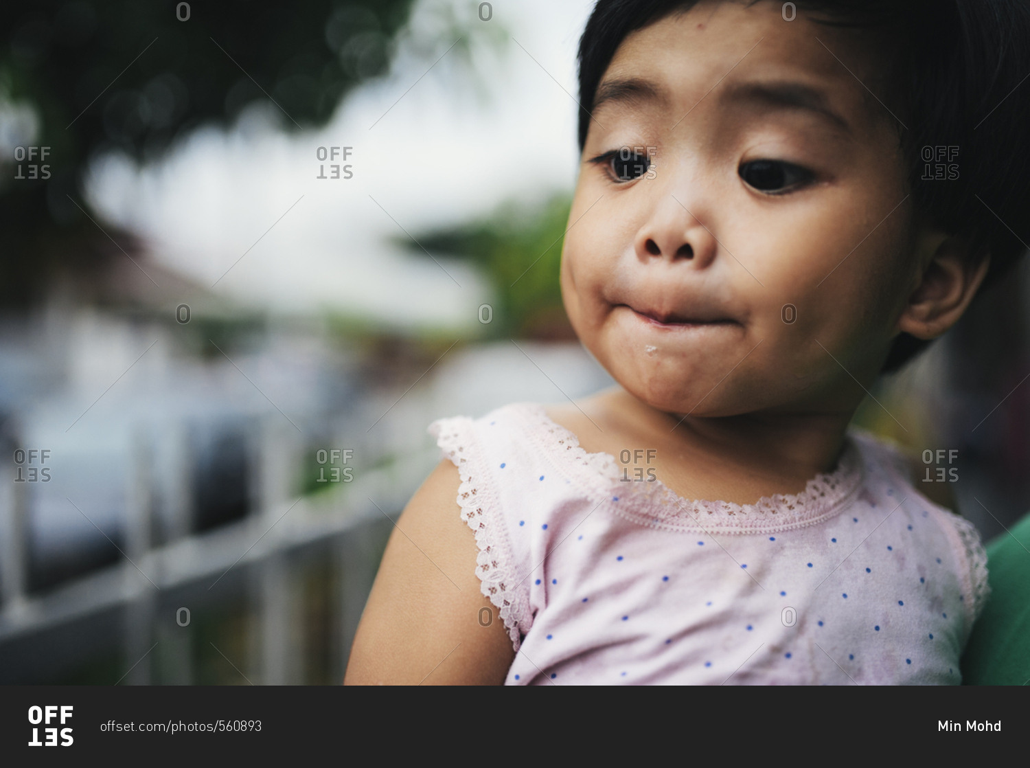 Malaysian toddler girl held outside stock photo - OFFSET