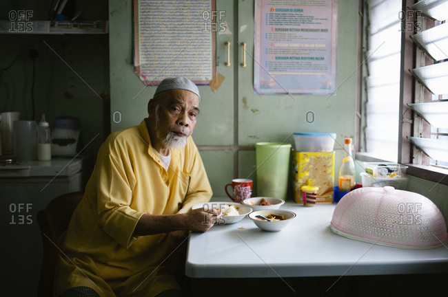 Malaysian man eating at a table