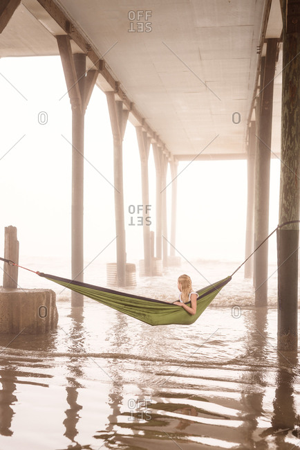 Girl in hammock under pier in Galveston, Texas