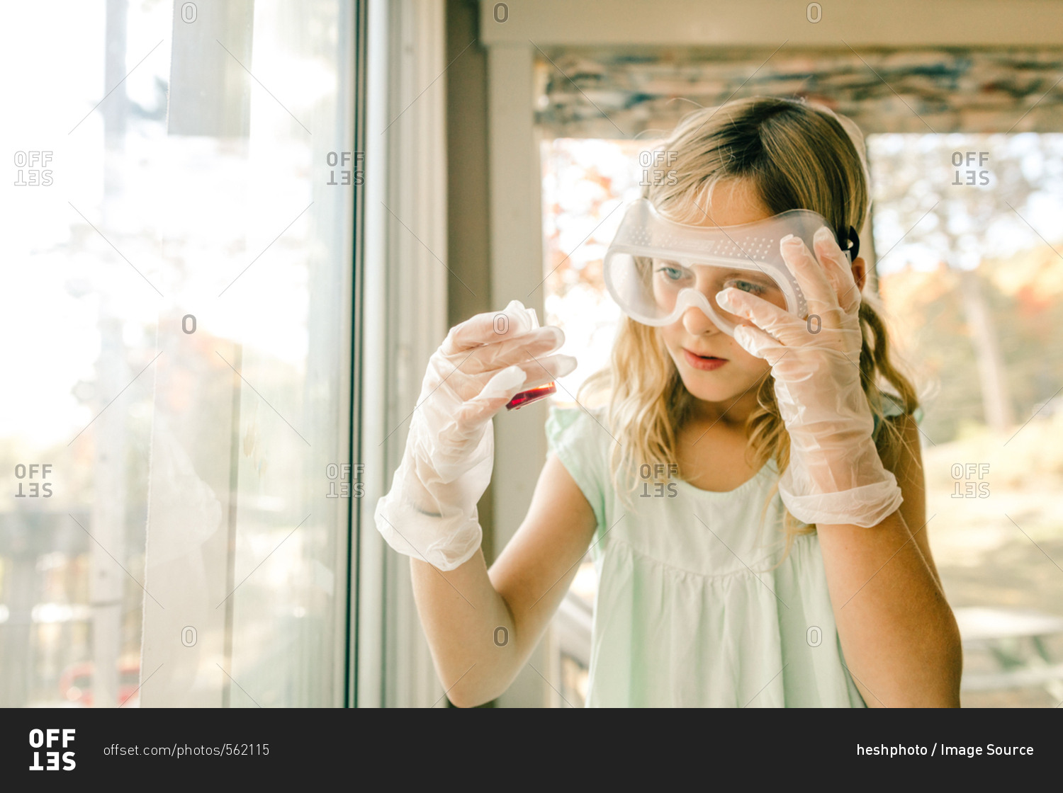 Girl doing science experiment, staring at measuring flask