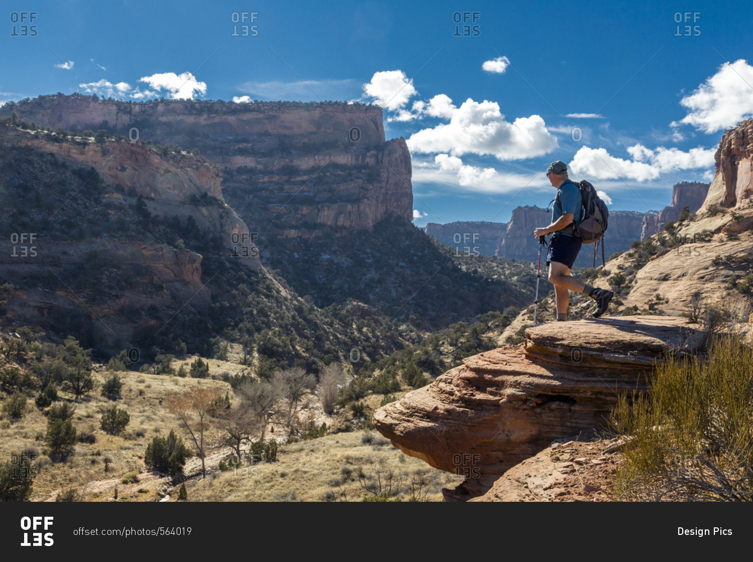 A male hiker enjoys a sunny view of the Colorado National Monument, Colorado, United States of America