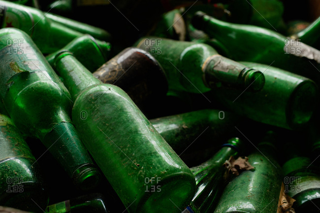 Reusable material. Close up view of dirty green glass bottles prepared for recycling