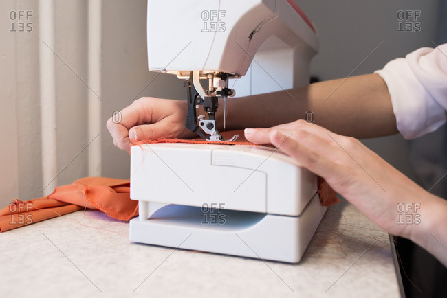 Hands sewing fabric at a machine