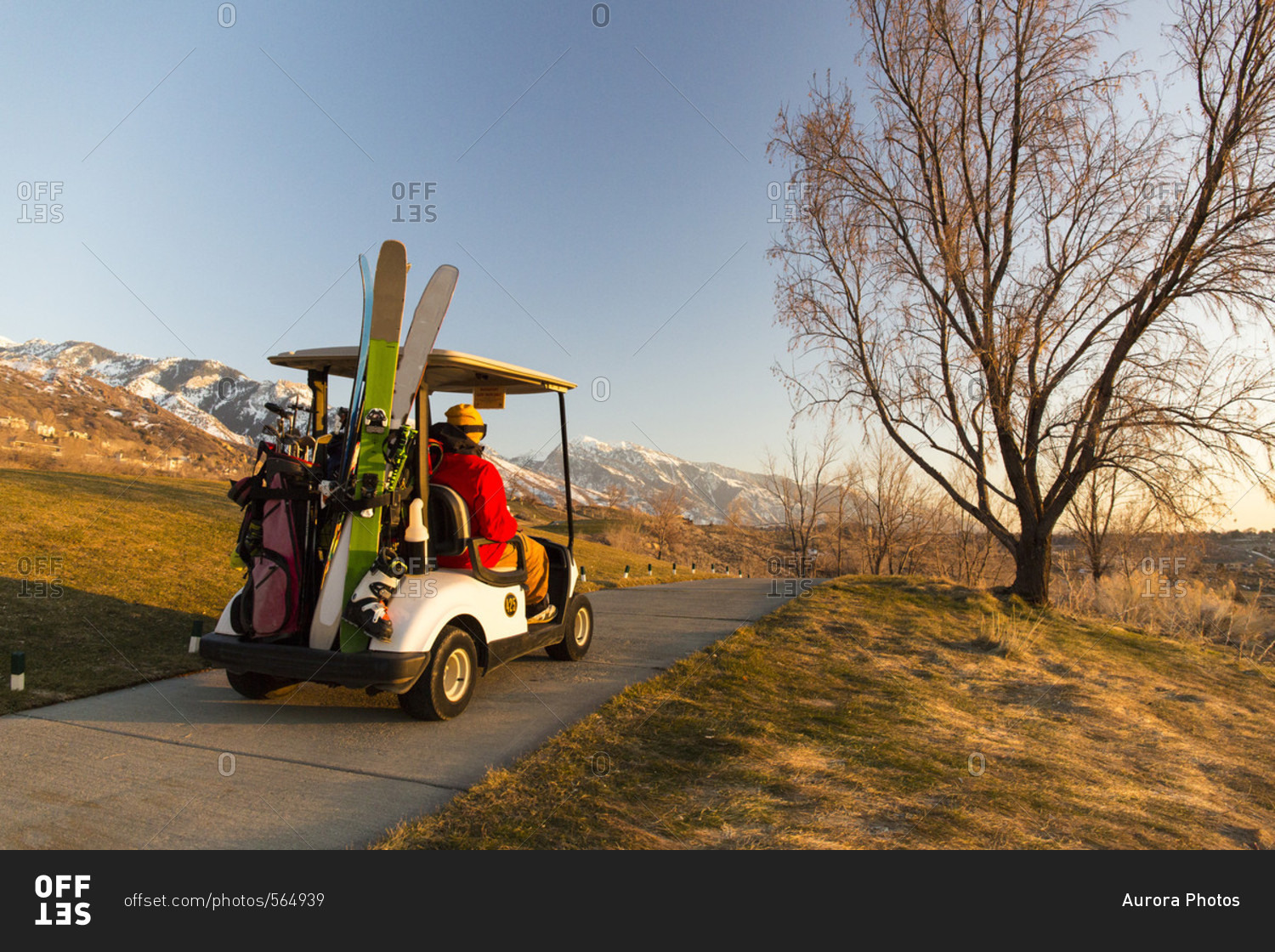 People on electric cart with skis at golf course