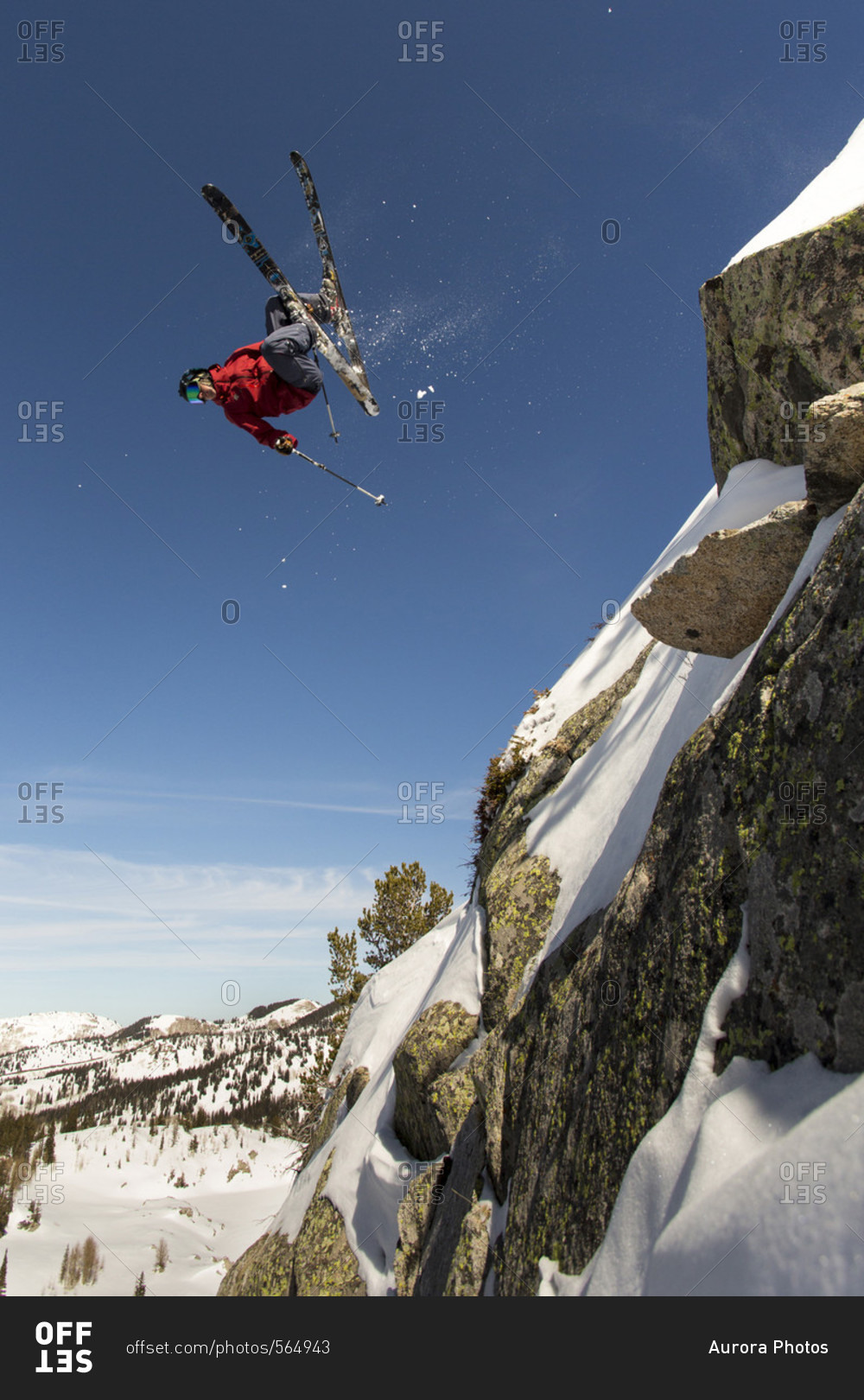 Extreme skier doing upside down stunt jump from cliff