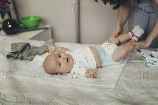 changing baby on bed