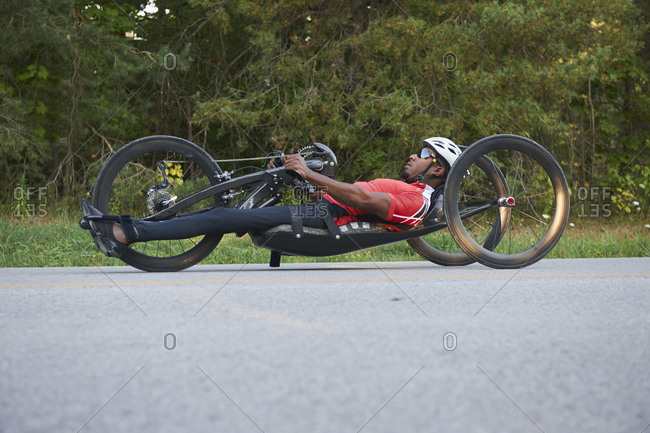 African American man riding hand cycle in street