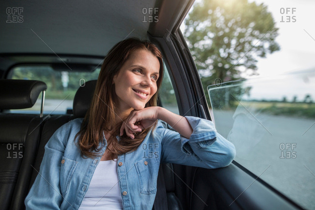 Mid adult woman looking through car window from front seat