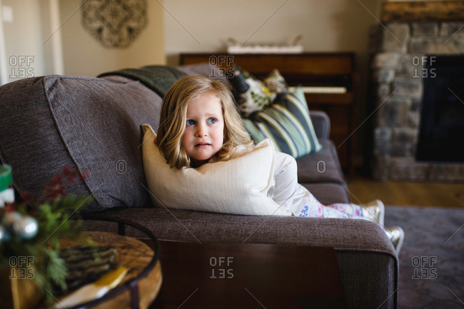 Fearful girl looking sideways from sofa