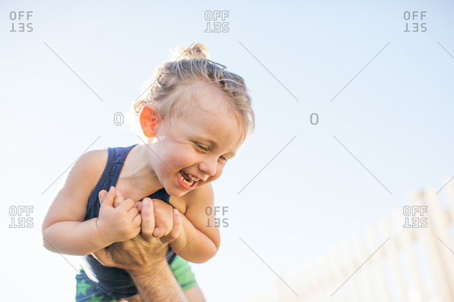 Young boy being lifted in air by father