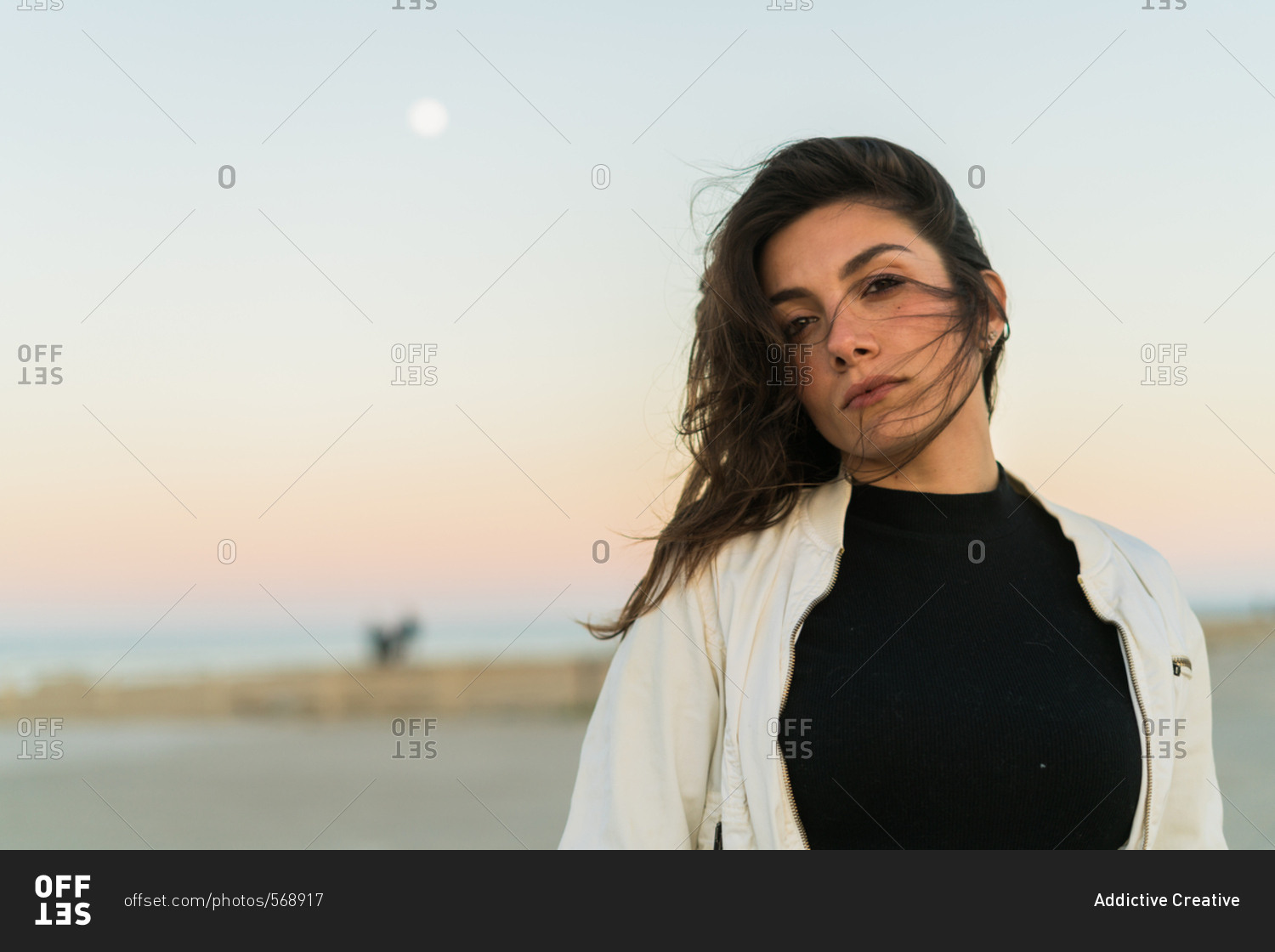 Young female looking unemotionally posing with hair waving on ...