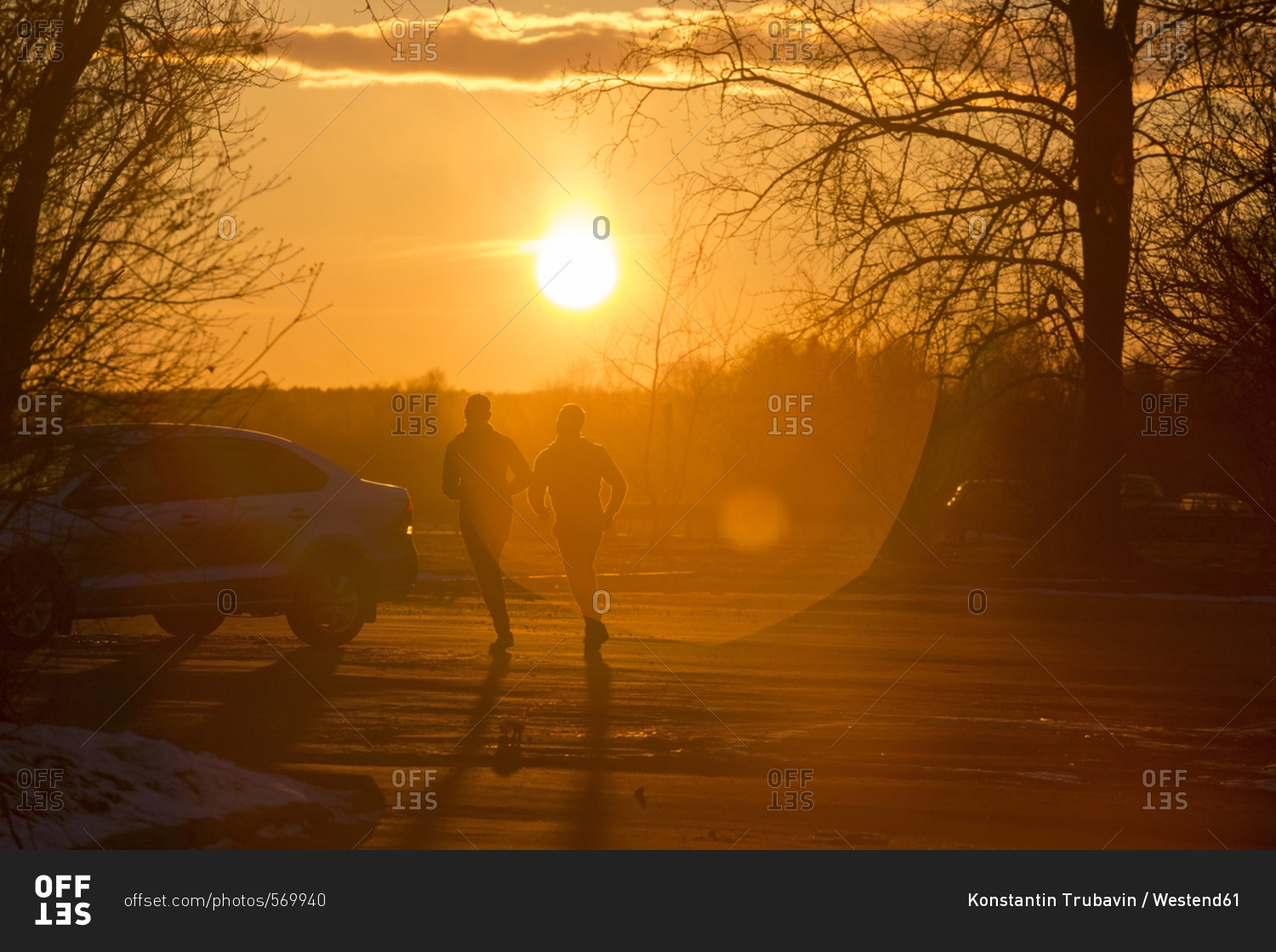 Silhouette of two joggers in winter at sunset