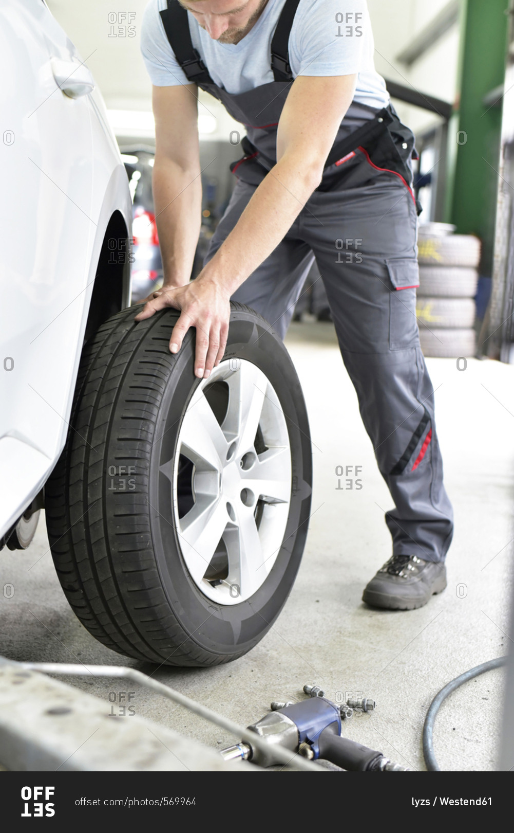 Car mechanic in a workshop changing car tire