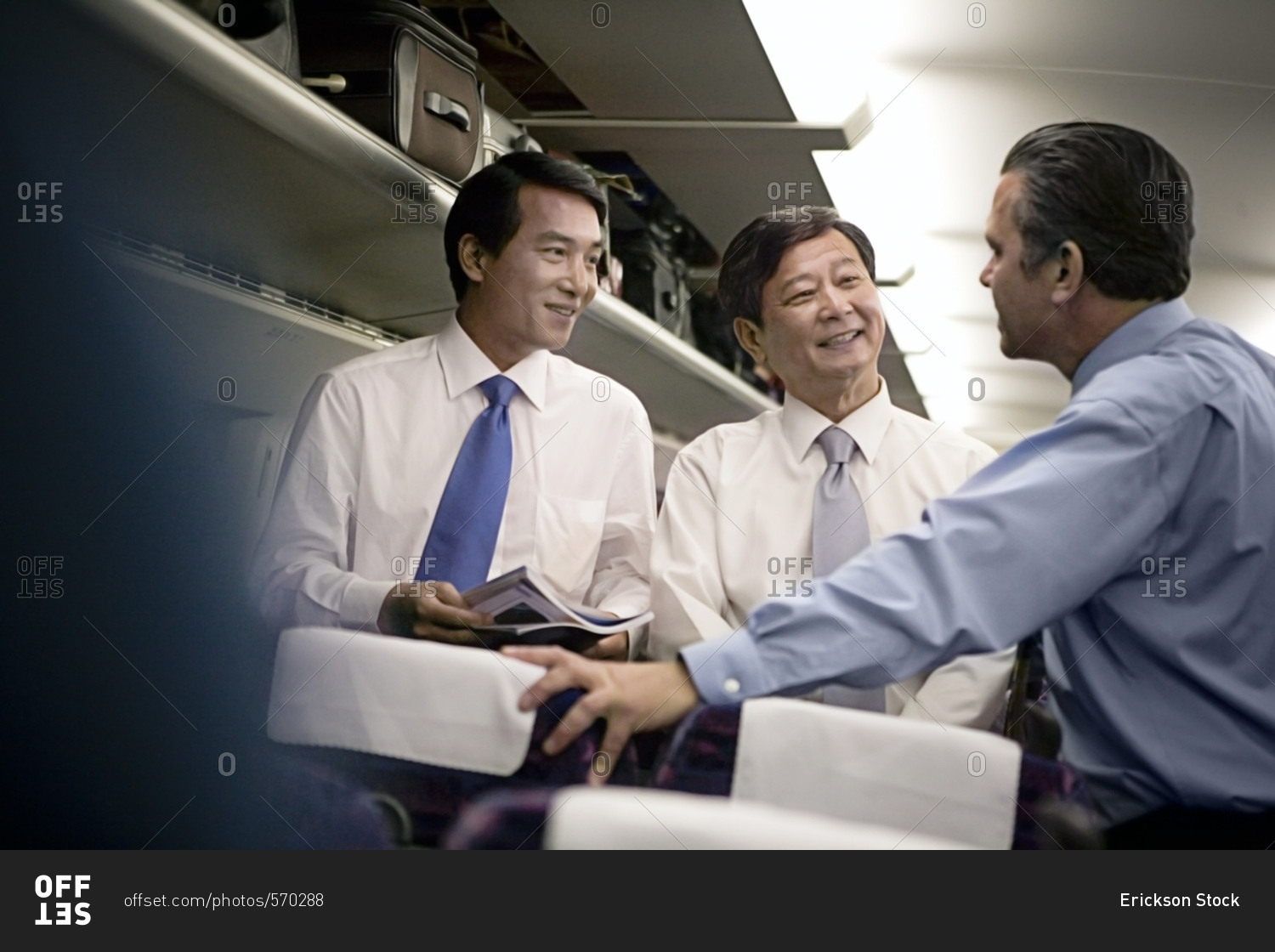 Businessmen talking in an airplane