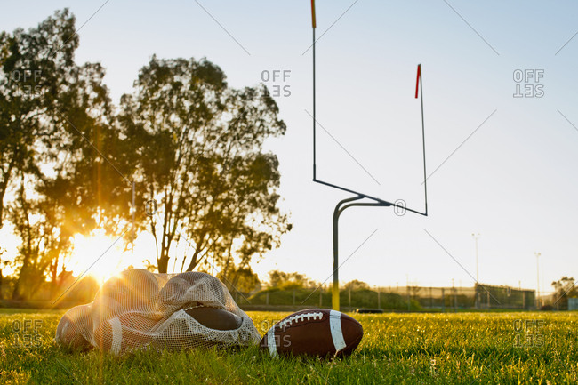 Footballs on a football field at sunset