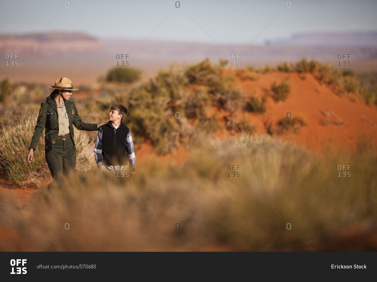 Park ranger walking with a boy in a desert