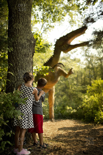 Children hiding from a dinosaur