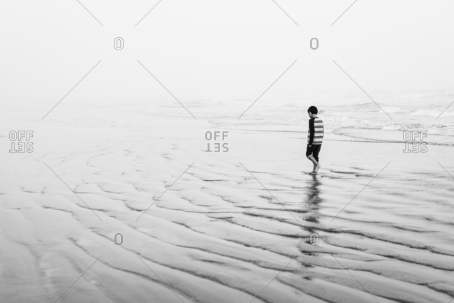 Boy walking in waves on Galveston Island, Texas