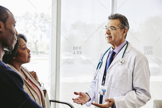 Doctor speaking to mother and son in waiting room
