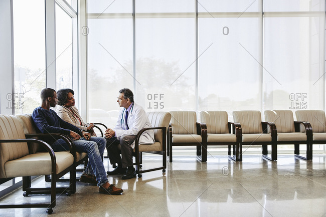 Doctor discussing with family while sitting hospital waiting room
