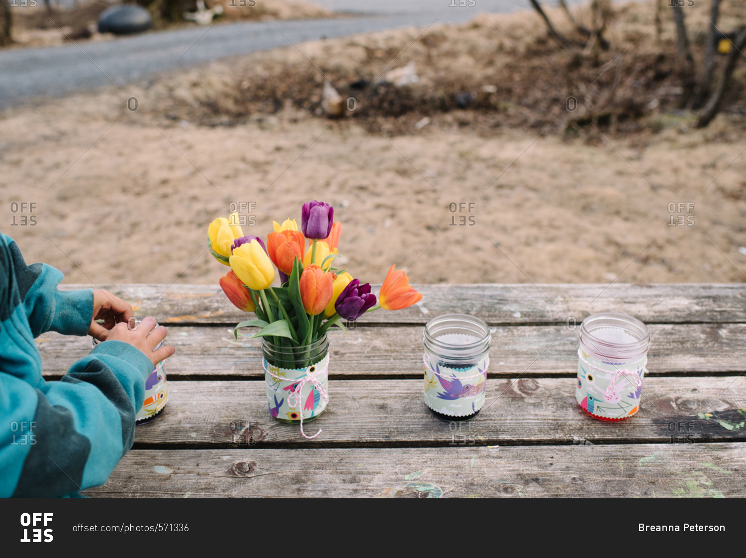 Vase of tulips with jars of Easter egg dye