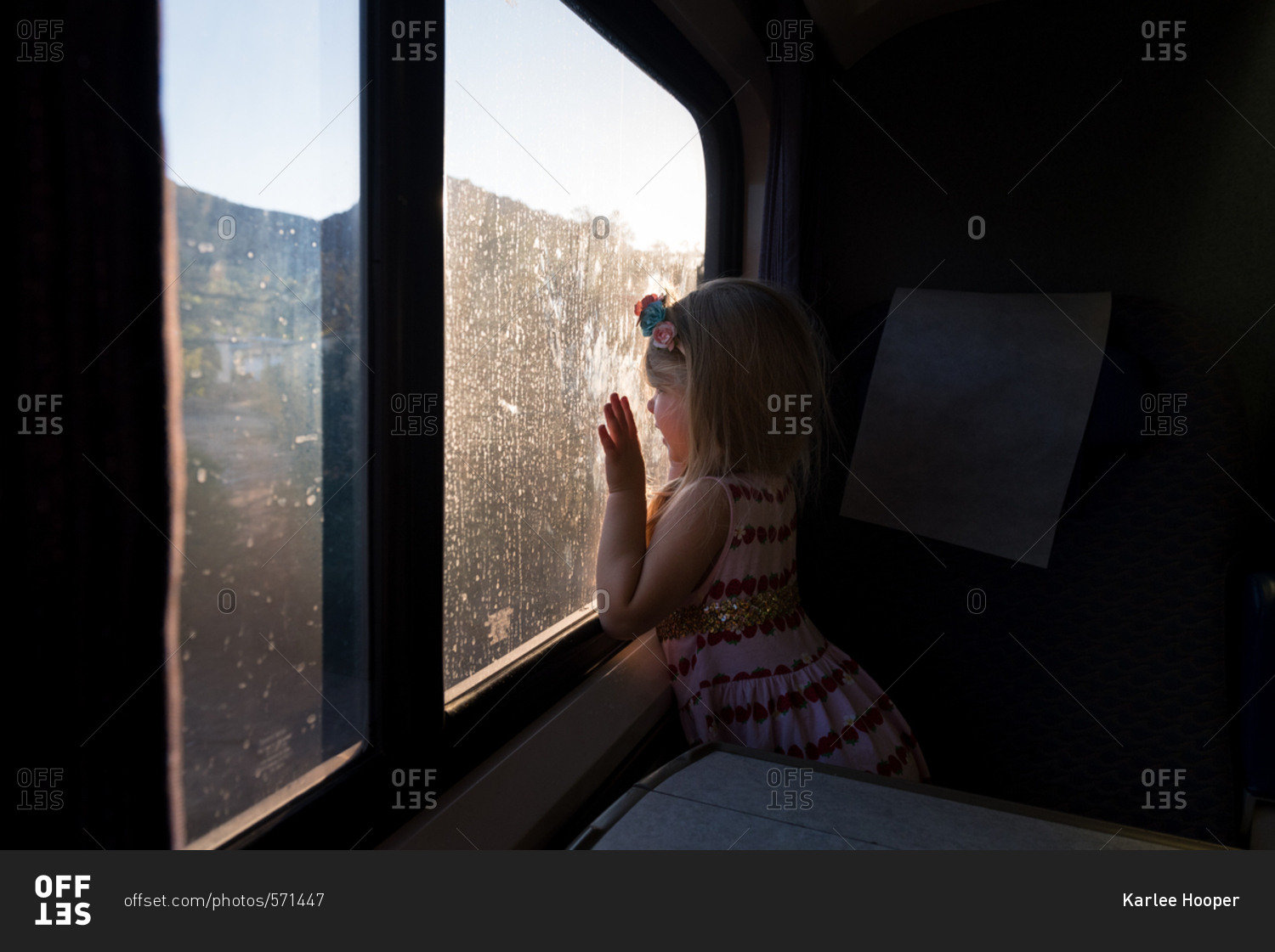 Little girl looking out of a dirty sunlit window