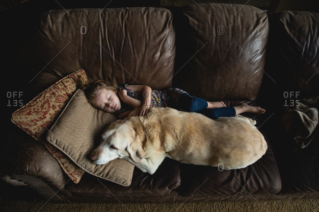 Girl asleep on couch with dog