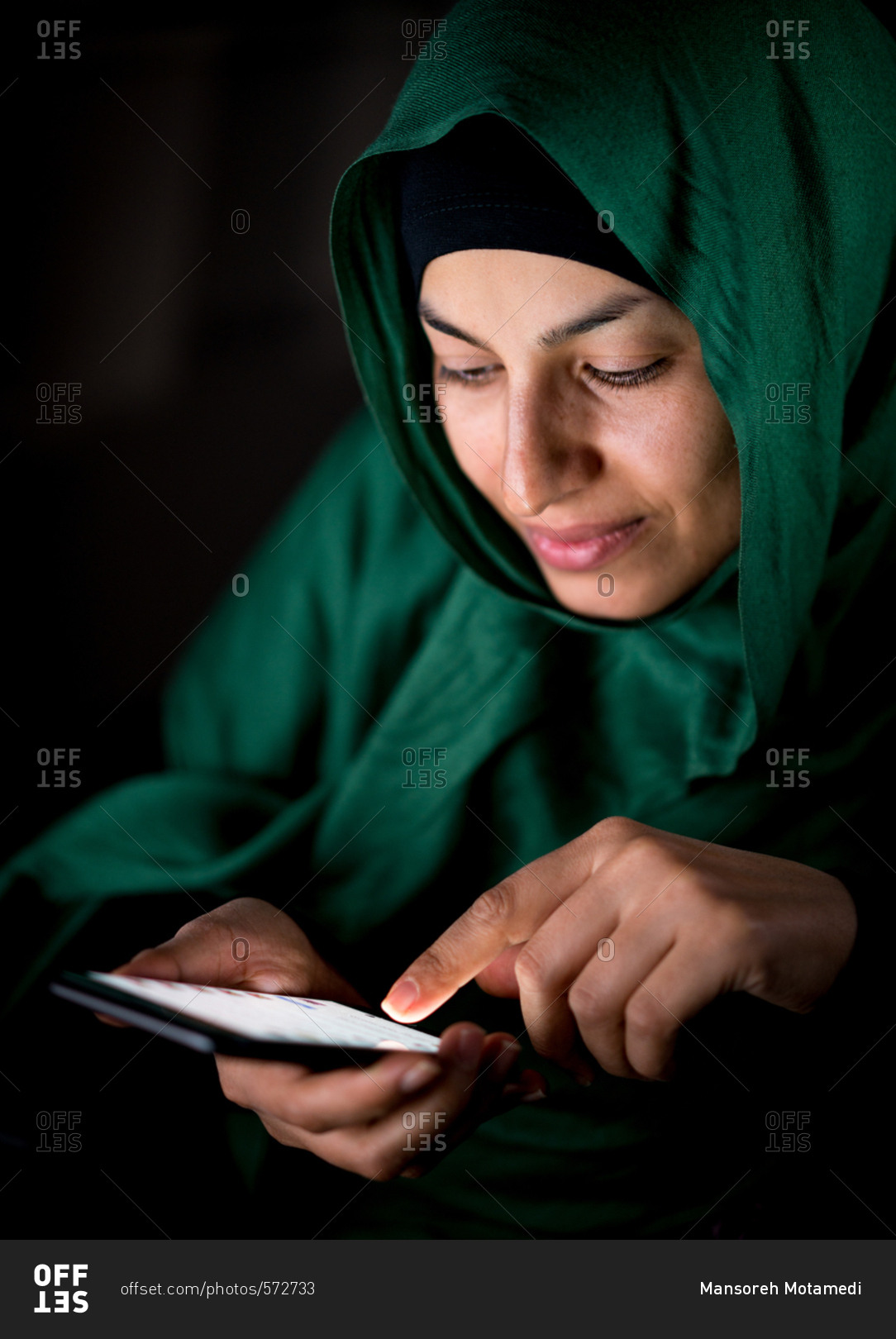 Happy Muslim woman using her phone