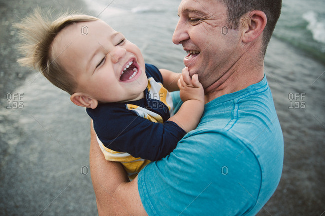 Laughing boy with his dad on beach