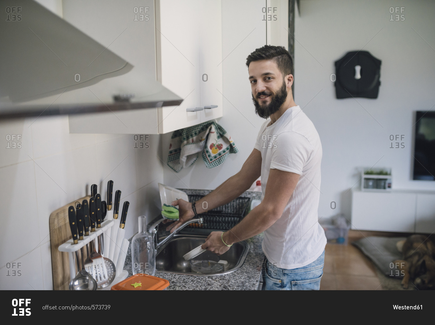 Young man washing dishes