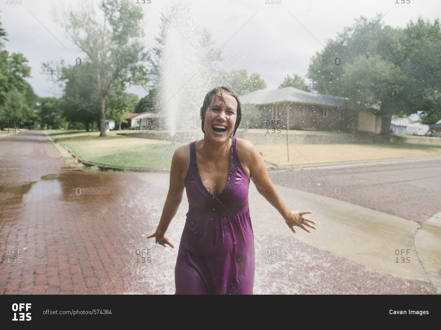 Cheerful woman standing against fountain at park