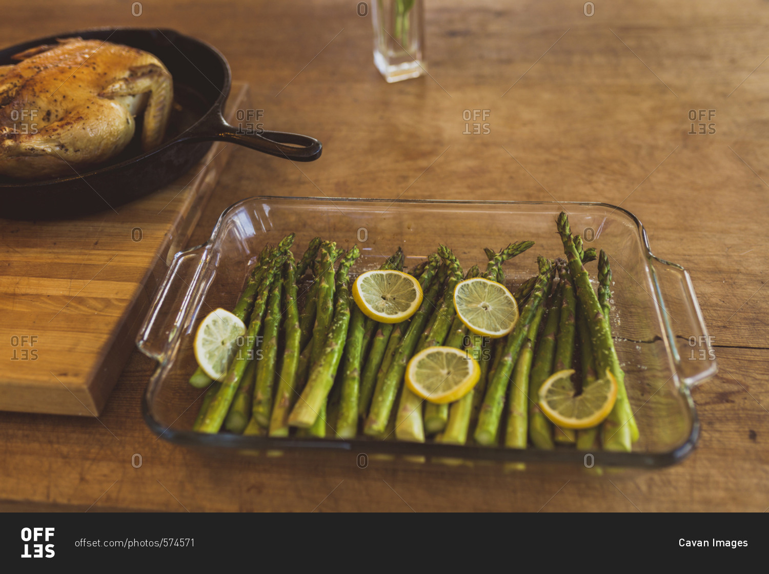 High angle view of asparagus and lemon in tray by chicken meat on table