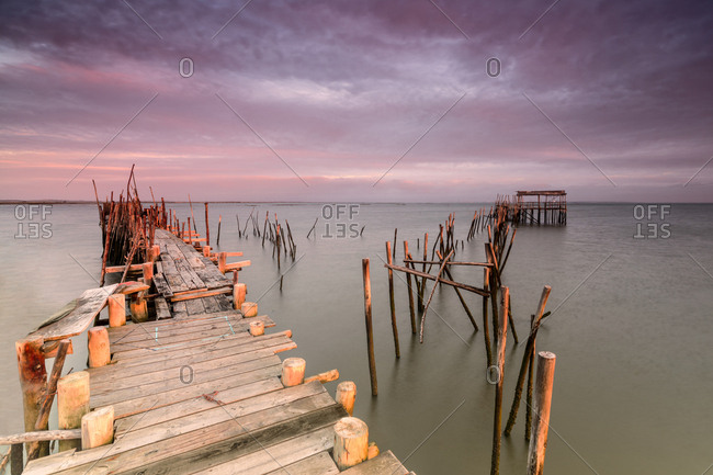 Pink sky at dawn on the Palafito Pier in the Carrasqueira Natural Reserve of Sado River Alcacer do Sal Setubal Portugal Europe