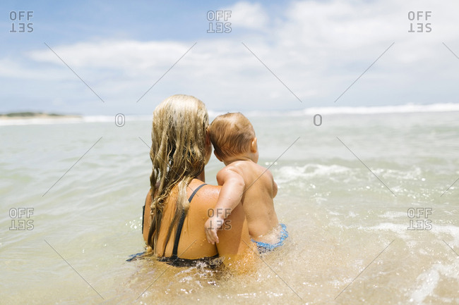 Mother playing with son (12-17 months) in sea