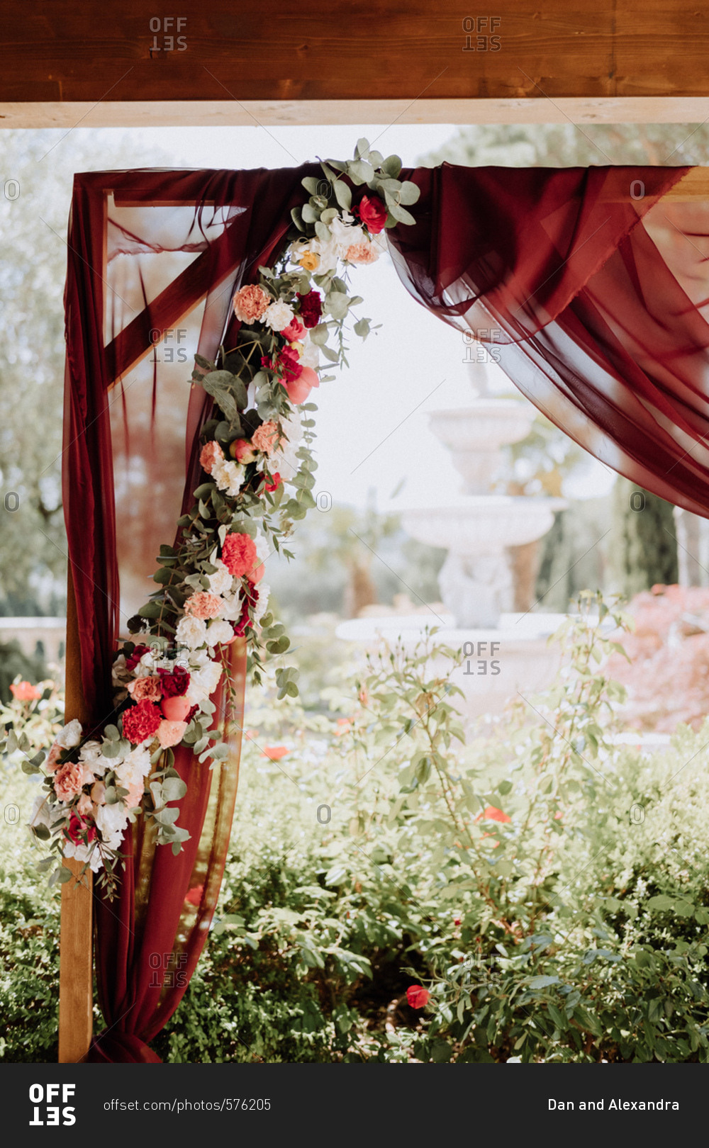 Wedding arbor with red curtains and flowers