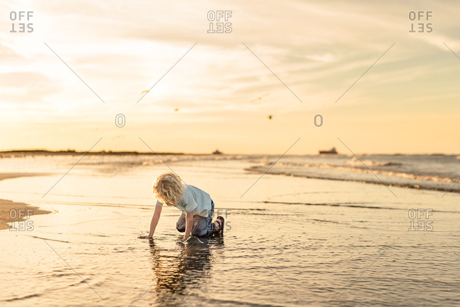 Boy playing on beach at sunset in Galveston, Texas