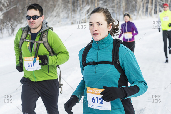 A group of runners competing during a winter road race.