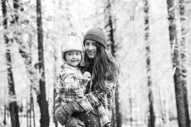 Teen girl and toddler girl in forest in flannels, in black and white