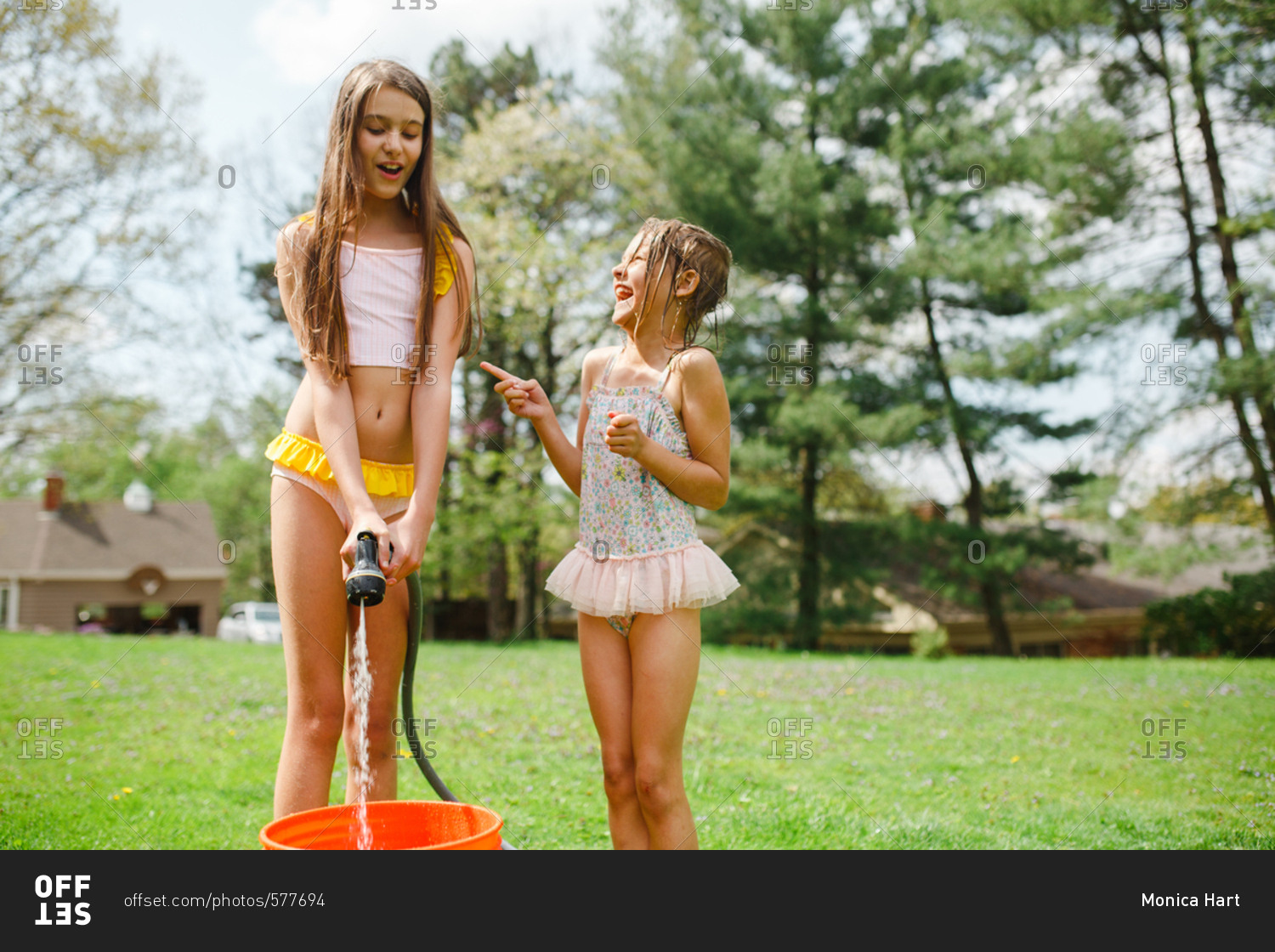 Girls filling bucket with hose stock photo OFFSET