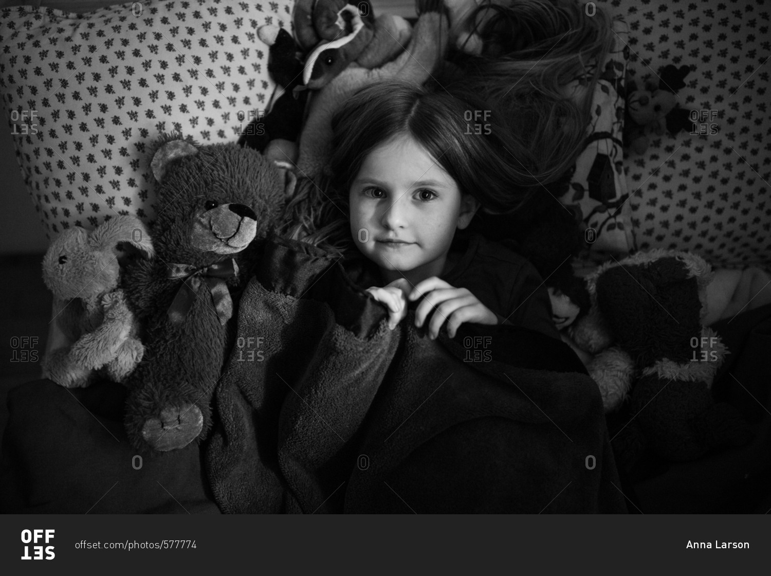 portrait-of-a-young-girl-lying-in-bed-in-black-and-white-stock-photo