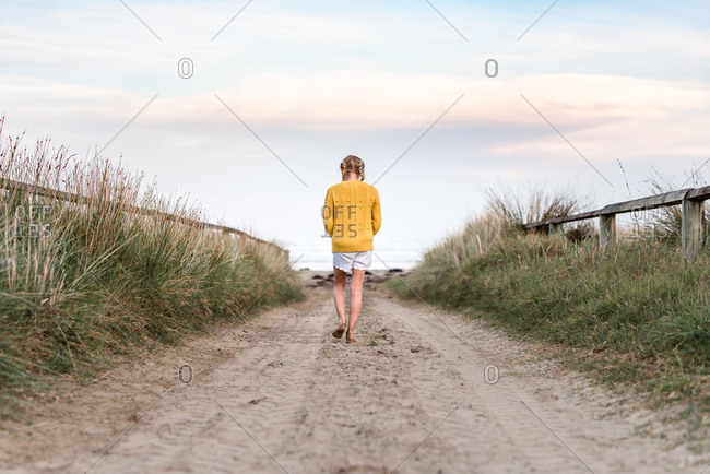 Girl walking on beach path