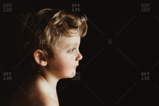 Boy in profile against black background