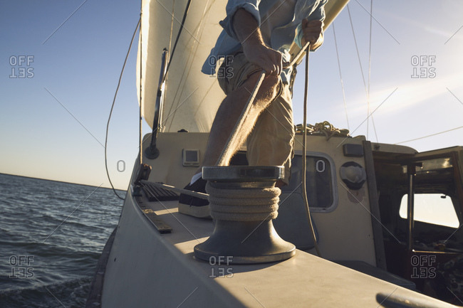 Low section of man pulling rigging on sailboat