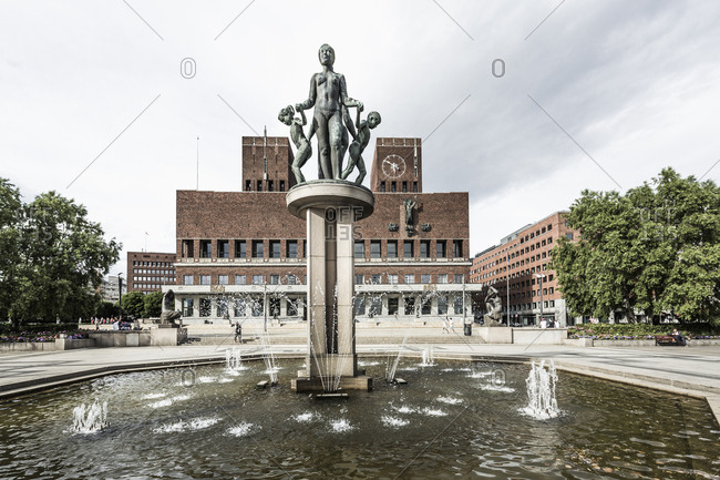 Norway, Oslo - June 12, 2017:  Gustav Vigeland sculpture in Oslo City Hall Square and Oslo City Hall