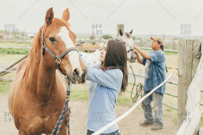 Native American father and daughter caring for their horses