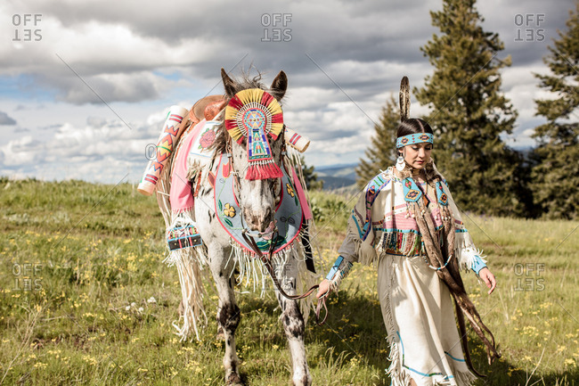 Native American girl in regalia walking with her horse on the Umatilla Reservation, Pendleton, Oregon