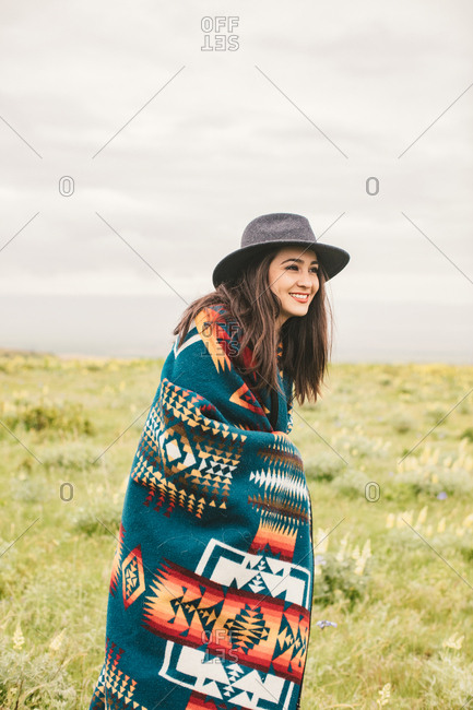 Portrait of a young woman wearing a western hat and woven blanket