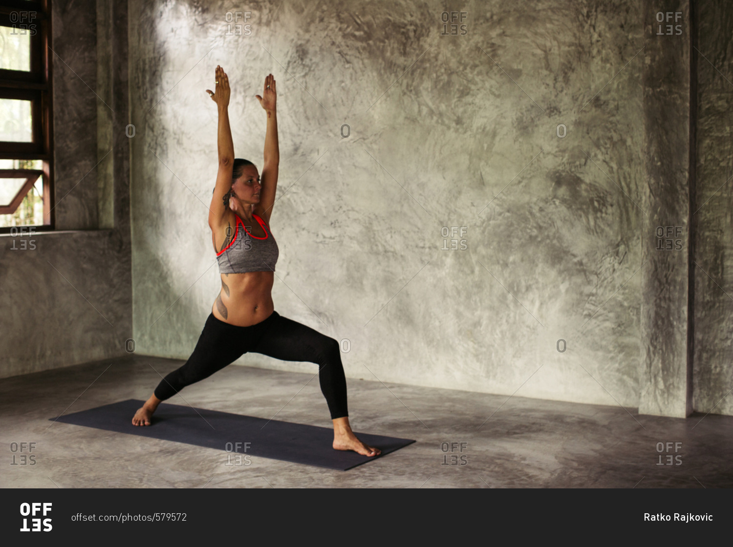 Woman in an industrial yoga studio performing a high lunge