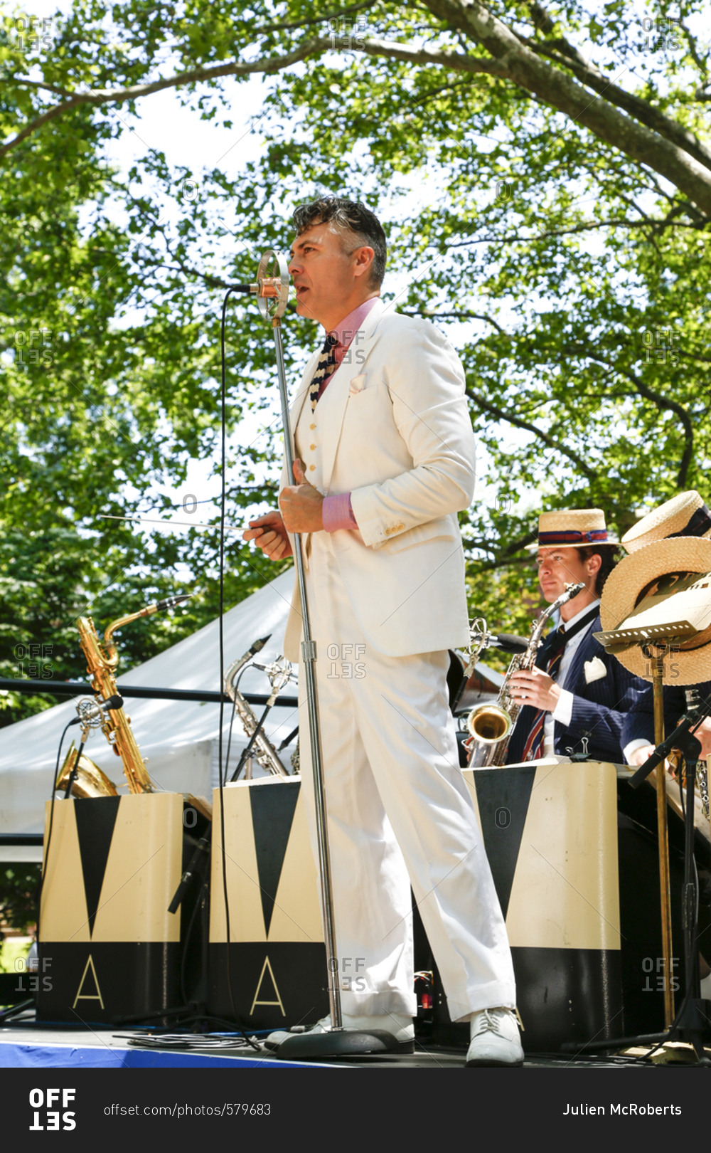 New York City, United States - June 10, 2017: 1920's Jazz
Age Lawn Party at Governors Island, Band leader singing into a
microphone at a garden party stock photo - OFFSET