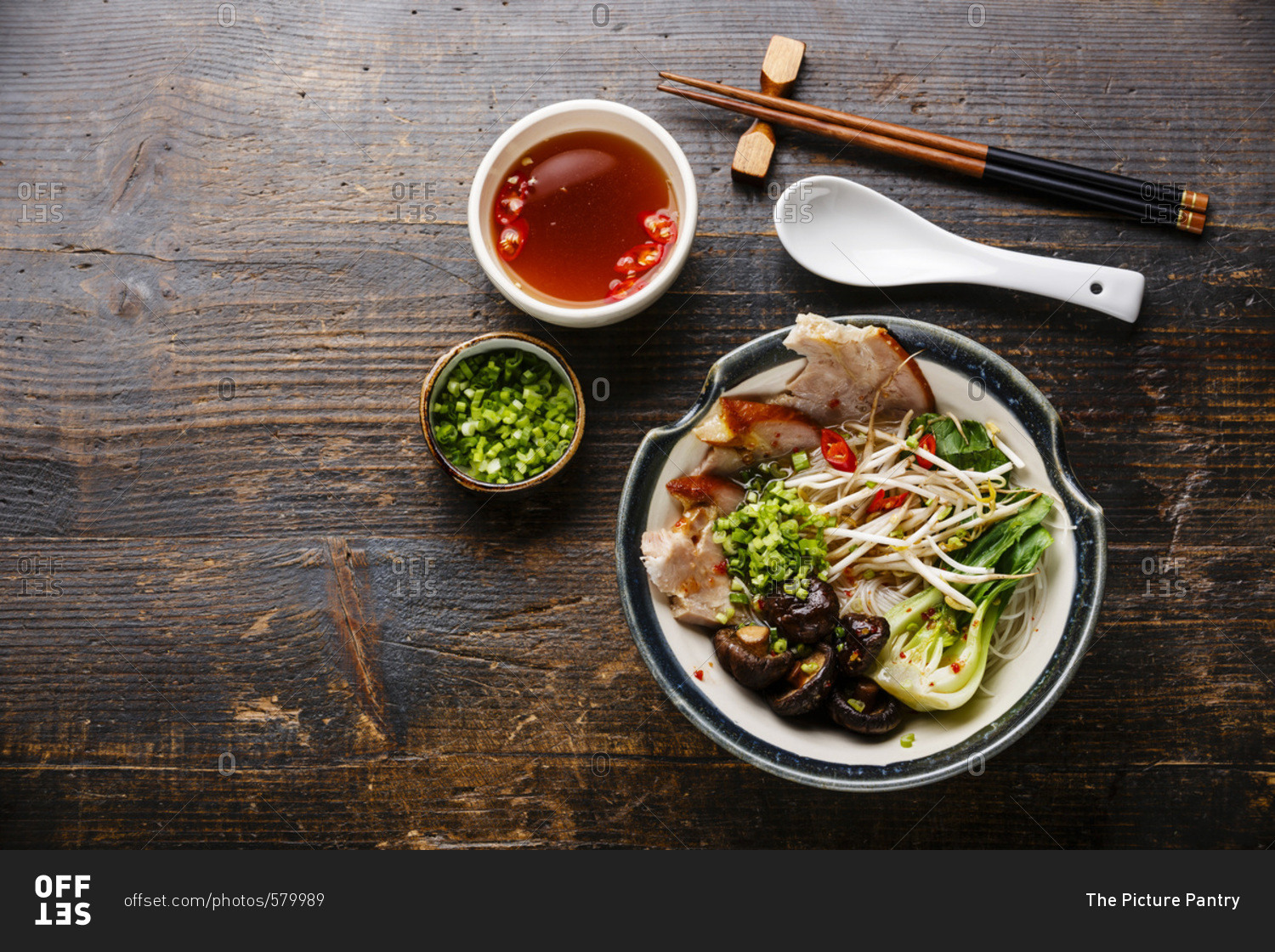 Rice noodles with boiled pork, wheat germ and shiitake mushrooms on wooden background copy space
